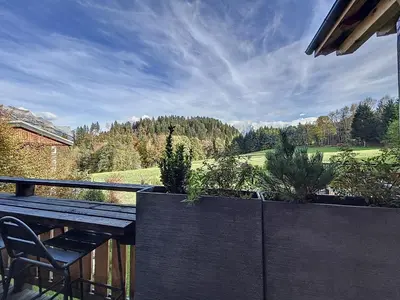 a table and chairs on a balcony with a view of a field at Chalet de luxe avec vue Mont Blanc et parking - FR-1-560-150 in Sallanches