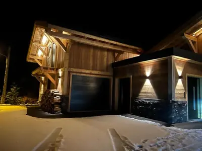 a house in the snow at night at Chalet de luxe avec vue Mont Blanc et parking - FR-1-560-150 in Sallanches