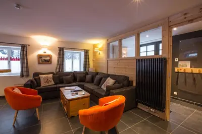 a living room with a couch and orange chairs at Chalet Atelier Chalet Chamonix in Chamonix-Mont-Blanc