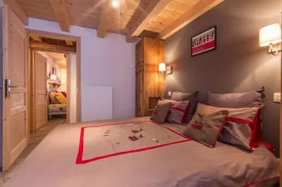 a bedroom with a large bed with a clock on it at Chalet Atelier Chalet Chamonix in Chamonix-Mont-Blanc