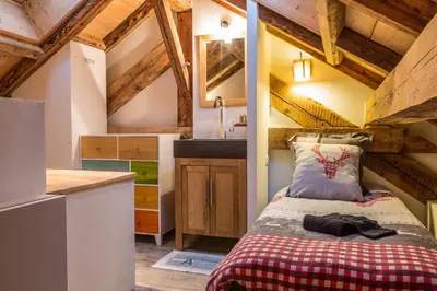 a bedroom with a bed and a kitchen with wooden ceilings at Chalet Atelier Chalet Chamonix in Chamonix-Mont-Blanc