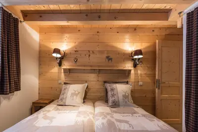 two beds in a room with a wooden wall at Chalet Atelier Chalet Chamonix in Chamonix-Mont-Blanc