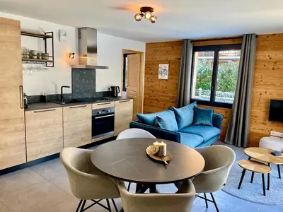 a kitchen and a living room with a table and chairs at Rêve du Criou in Samoëns