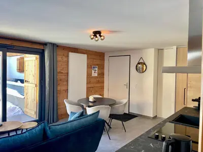a living room with a couch and a table and chairs at Rêve du Criou in Samoëns