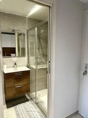 a bathroom with a glass shower and a sink at Joli petit studio neuf in Saint-Gervais-les-Bains