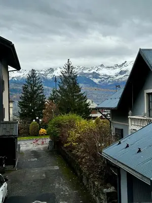 a view of snow capped mountains from a residential street at Joli petit studio neuf in Saint-Gervais-les-Bains