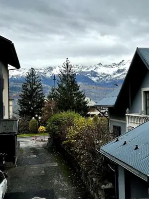 a view of snow capped mountains from a street at Joli petit studio neuf in Saint-Gervais-les-Bains