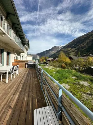 a wooden deck with a table and chairs on a building at 70sqm in heart of chamonix in Chamonix-Mont-Blanc
