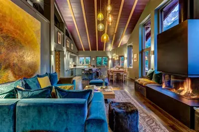 a living room with a blue couch and a fireplace at Chalet Hibou in Chamonix-Mont-Blanc