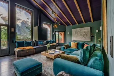 a living room with blue furniture and green walls at Chalet Hibou in Chamonix-Mont-Blanc