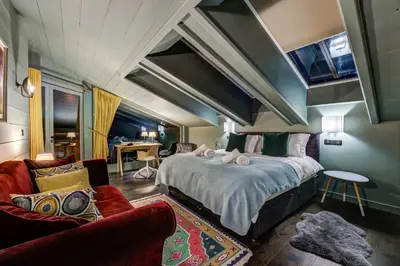 a bedroom with a large bed and a living room at Chalet Hibou in Chamonix-Mont-Blanc