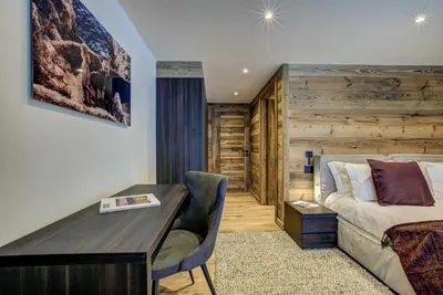 a hotel room with a bed and a desk and a couch at Chalet Freya in Chamonix-Mont-Blanc