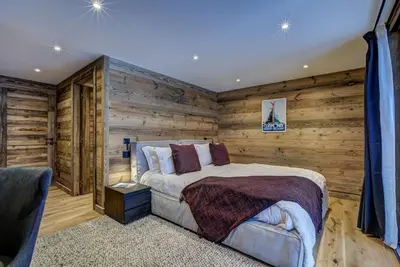 a bedroom with a bed in a wooden wall at Chalet Freya in Chamonix-Mont-Blanc