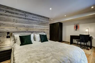 a bedroom with a large bed with a wooden wall at Chalet Freya in Chamonix-Mont-Blanc