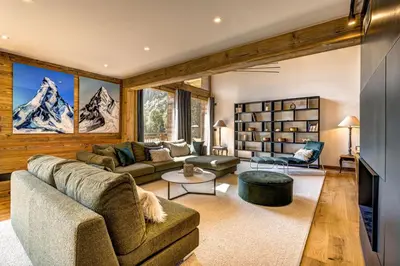 a living room with wooden walls and a table and chairs at Chalet Freya in Chamonix-Mont-Blanc
