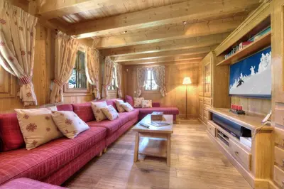 a living room with a red couch and a flat screen tv at Chalet Nidaya in Les Houches