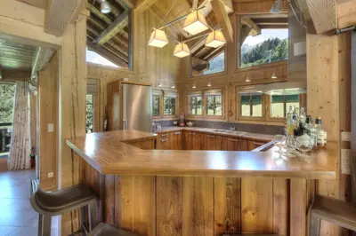 a large kitchen with wooden walls and a large island at Chalet Nidaya in Les Houches