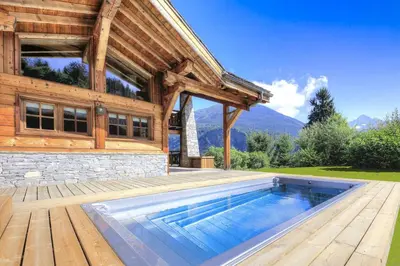 a house with a swimming pool in front of a building at Chalet Nidaya in Les Houches