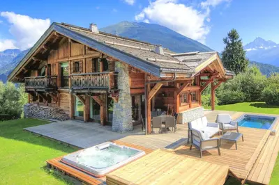 a log cabin with a deck and a swimming pool at Chalet Nidaya in Les Houches