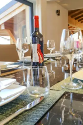a bottle of wine sitting on a table with glasses at Chalet Kuma in Les Houches