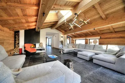 a living room with couches and a wooden ceiling at Chalet Kuma in Les Houches