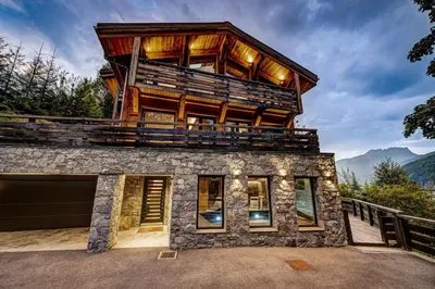a house with a balcony on top of it at Chalet Kuma in Les Houches