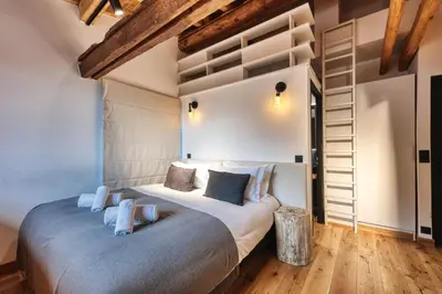 a bedroom with a large bed in a room with wooden floors at Le Marti in Chamonix-Mont-Blanc