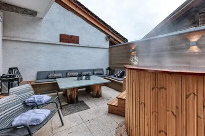 a patio with a bar and a table and chairs at Le Marti in Chamonix-Mont-Blanc