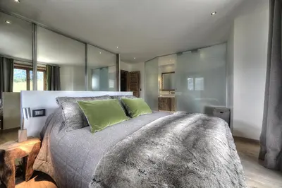 a bedroom with a large bed with green pillows at Chalet Norel in Les Houches