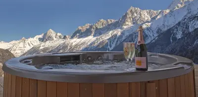 a hot tub with a bottle of champagne and a glass at Chalet Norel in Les Houches