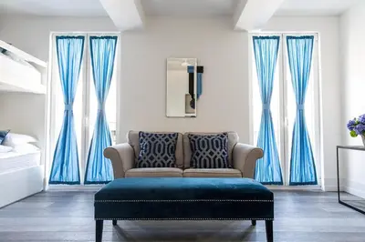 a living room with blue curtains and a couch at Penthouse Le Lustre in Chamonix-Mont-Blanc