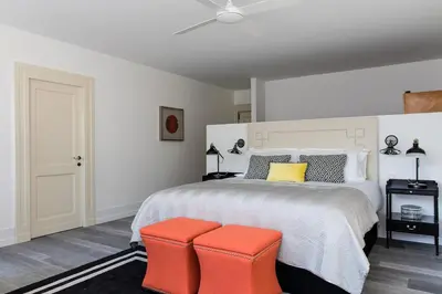 a bedroom with a bed with two orange stools at Penthouse Le Lustre in Chamonix-Mont-Blanc