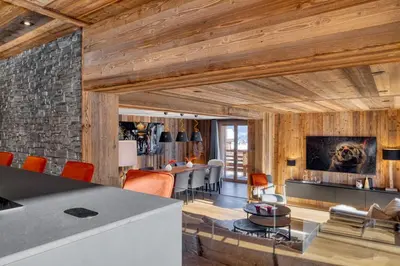 a living room with wood paneling and a stone wall at Appartement Élégance Mont Blanc - Welkeys in Combloux