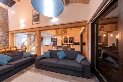 a living room with two couches and a table at Le Bord Du Nant in Arâches-la-Frasse