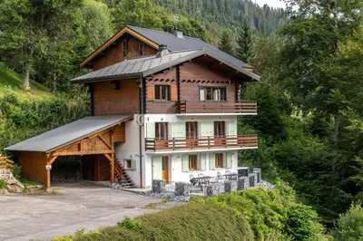 a large wooden house on top of a hill at Le Bord Du Nant in Arâches-la-Frasse