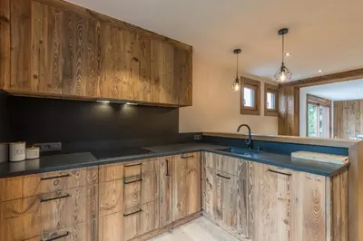 a kitchen with wooden cabinets and a sink at Le Refuge contemporain - Welkeys in Megève