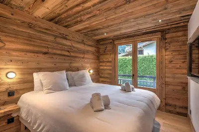 a bedroom with a bed in a log cabin at Le Refuge contemporain - Welkeys in Megève
