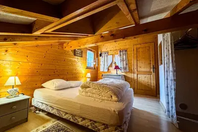 a bedroom with a bed in a wooden cabin at Chalet facing Mont Blanc calm and comfort in Saint-Gervais-les-Bains