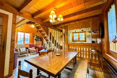 a dining room with a wooden table in a house at Chalet facing Mont Blanc calm and comfort in Saint-Gervais-les-Bains