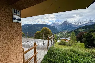 a view of mountains from a wooden deck with birds on it at Chalet facing Mont Blanc calm and comfort in Saint-Gervais-les-Bains
