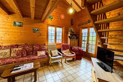 a living room with a couch and a tv in a log cabin at Chalet facing Mont Blanc calm and comfort in Saint-Gervais-les-Bains