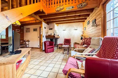 a living room with a couch and a tv in a room at Chalet facing Mont Blanc calm and comfort in Saint-Gervais-les-Bains