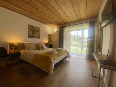 a bedroom with a large bed and a large window at Du Côté de Chez Sou in Arâches-la-Frasse