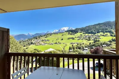 a table on a balcony with a view of a mountain at Apartment Les Cimes Blanches in Combloux