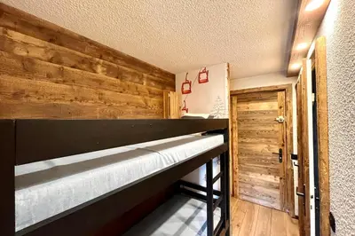 a bunk bed in a room with a wooden wall at Apartment Les Cimes Blanches in Combloux