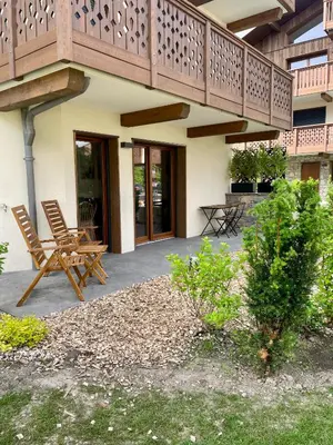 a patio with two chairs and a balcony at appartement chaleureux 60m2 neuf à proximité de tout, proche centre Samoëns in Samoëns