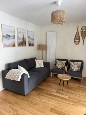 a living room with a blue couch and two chairs at appartement chaleureux 60m2 neuf à proximité de tout, proche centre Samoëns in Samoëns