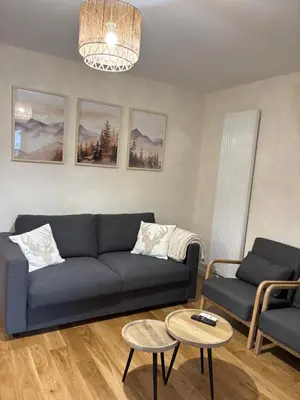 a living room with a couch and a table at appartement chaleureux 60m2 neuf à proximité de tout, proche centre Samoëns in Samoëns
