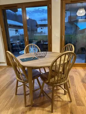 a wooden table with four chairs around it at appartement chaleureux 60m2 neuf à proximité de tout, proche centre Samoëns in Samoëns