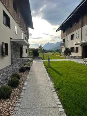 a walkway in front of a building with a lawn at appartement chaleureux 60m2 neuf à proximité de tout, proche centre Samoëns in Samoëns